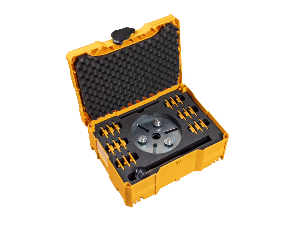 PALLMANN_dummy_DIAMOND SEGMENT TRANSPORTBOX open_zudem_2019-08 Open geel-oranje kunststof gereedschapskoffer met eierdoosachtig schuim in het deksel en op maat gemaakte schuiminzetstukken die een ronde metalen gereedschapskop en meerdere kleine opzetstukken bevatten, gefotografeerd op een witte achtergrond.